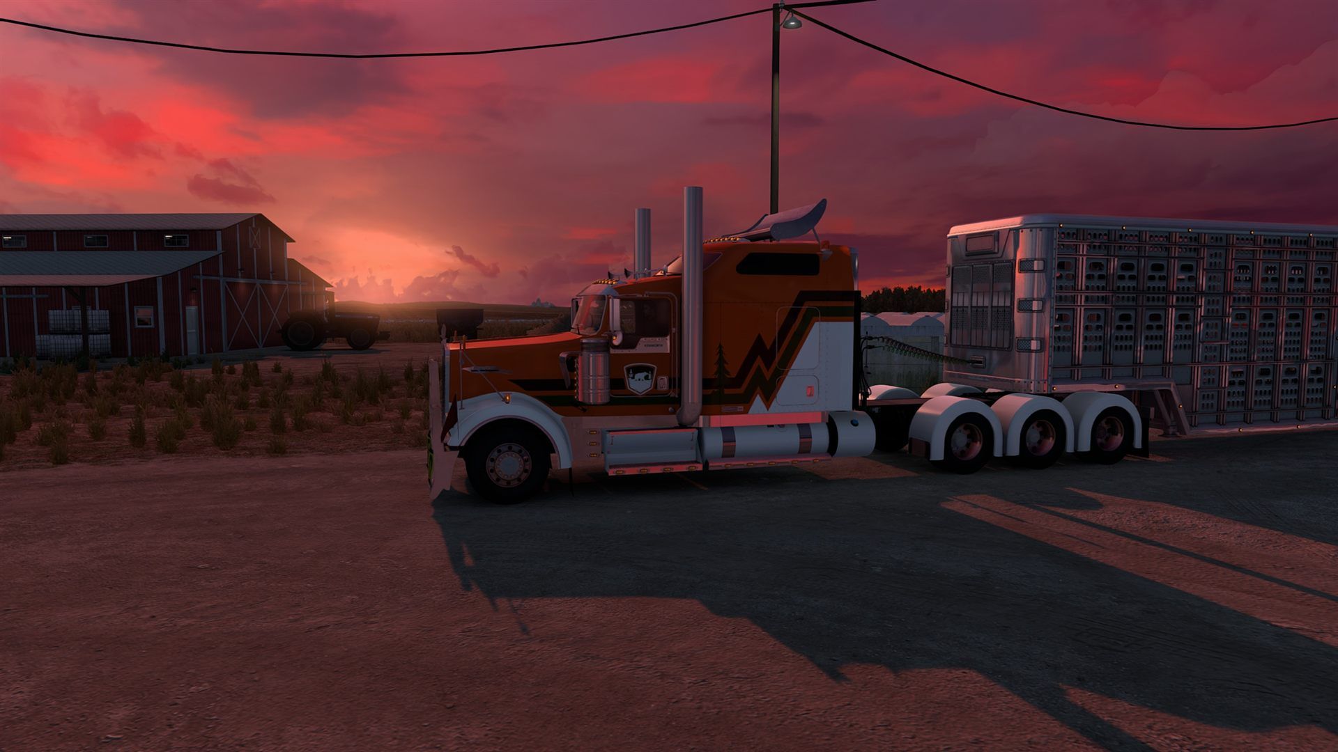 An orange and white Kenworth W900 hitched to a livestock trailer, in front of a red barn, under a pink sunset in American Truck Simulator.