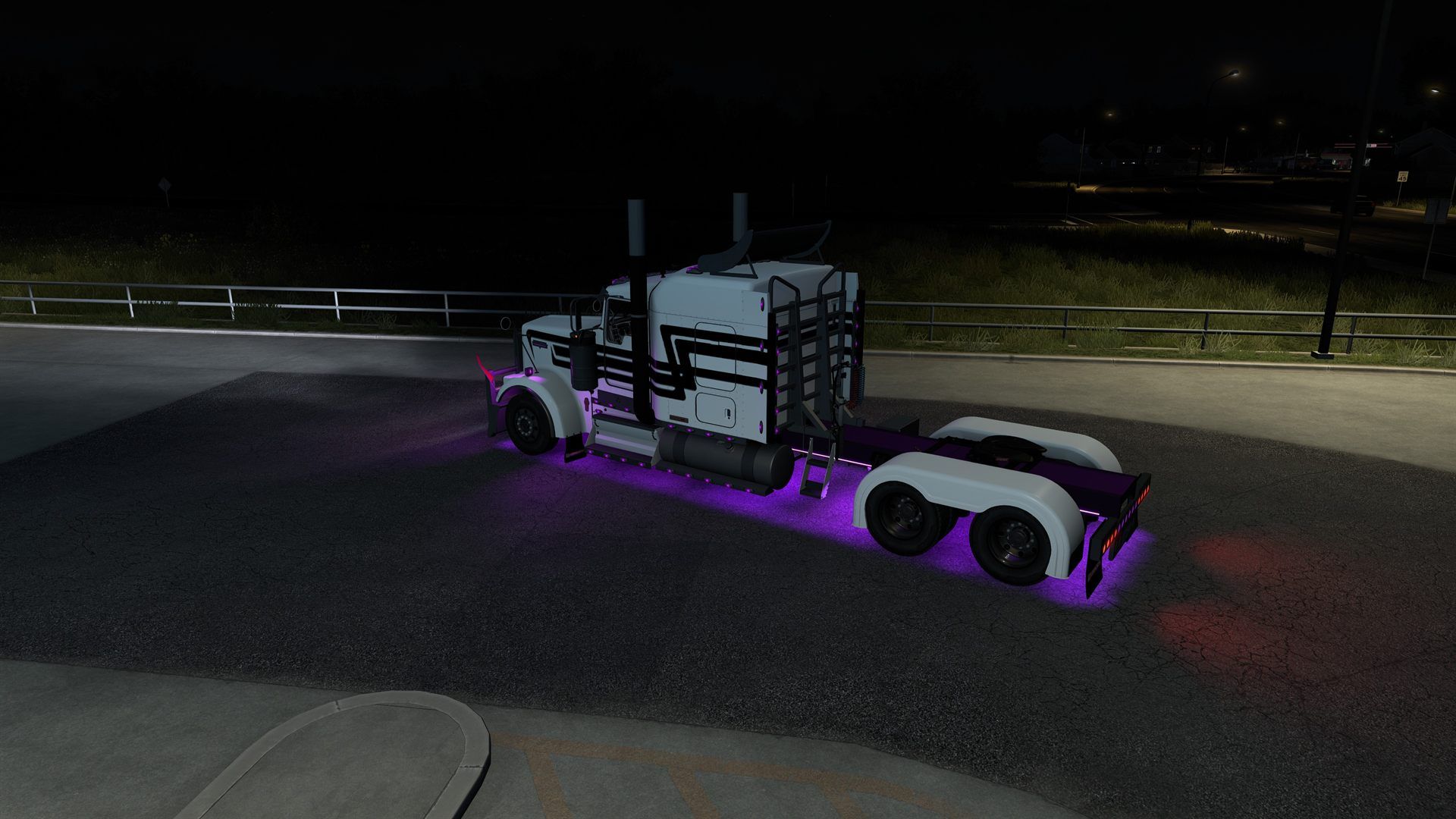 Un Kenworth W900 blanc à rayures noires, éclairé de mauve sous le châssis par le néon Overdrive, la nuit, dans American Truck Simulator.